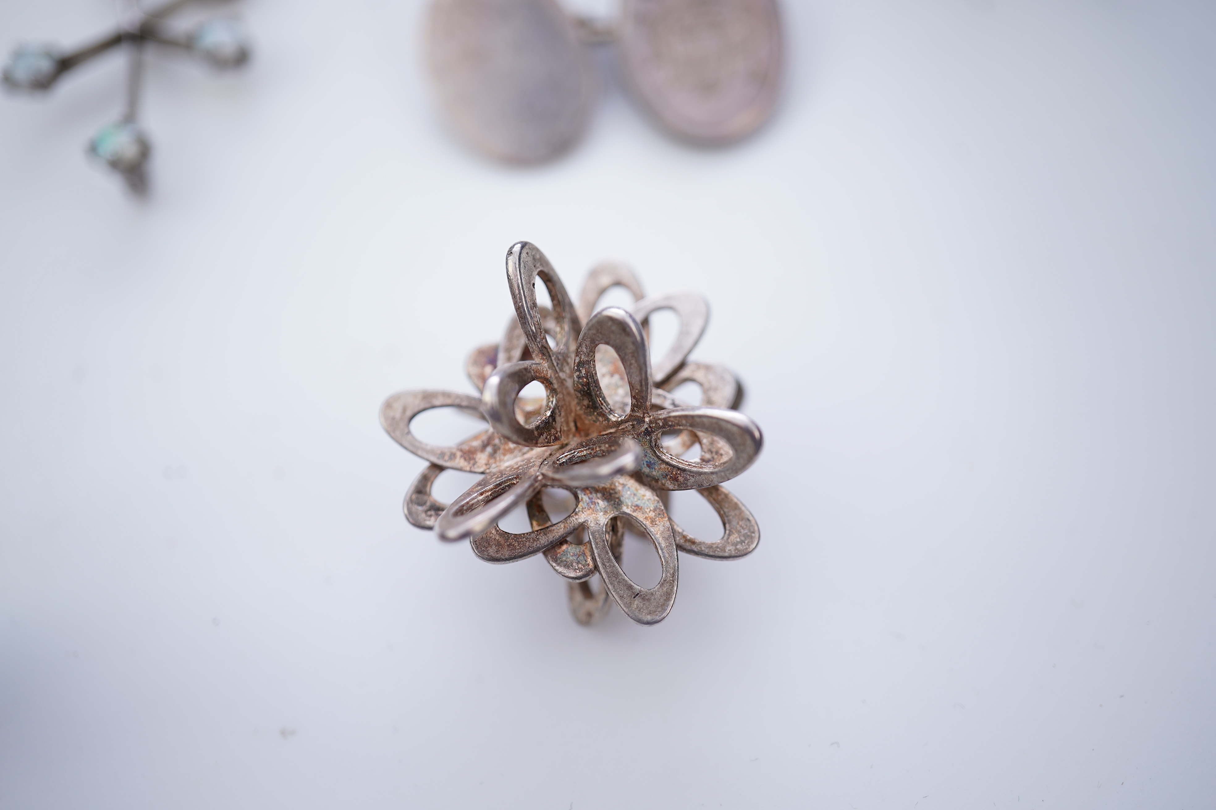 A collection of silver jewels, comprising: a bangle; a chain necklace suspending two winding toothpicks, one with toothpick deficient; a rope twist chain; a pair of cufflinks with the initials DBH; a pendant of abstract